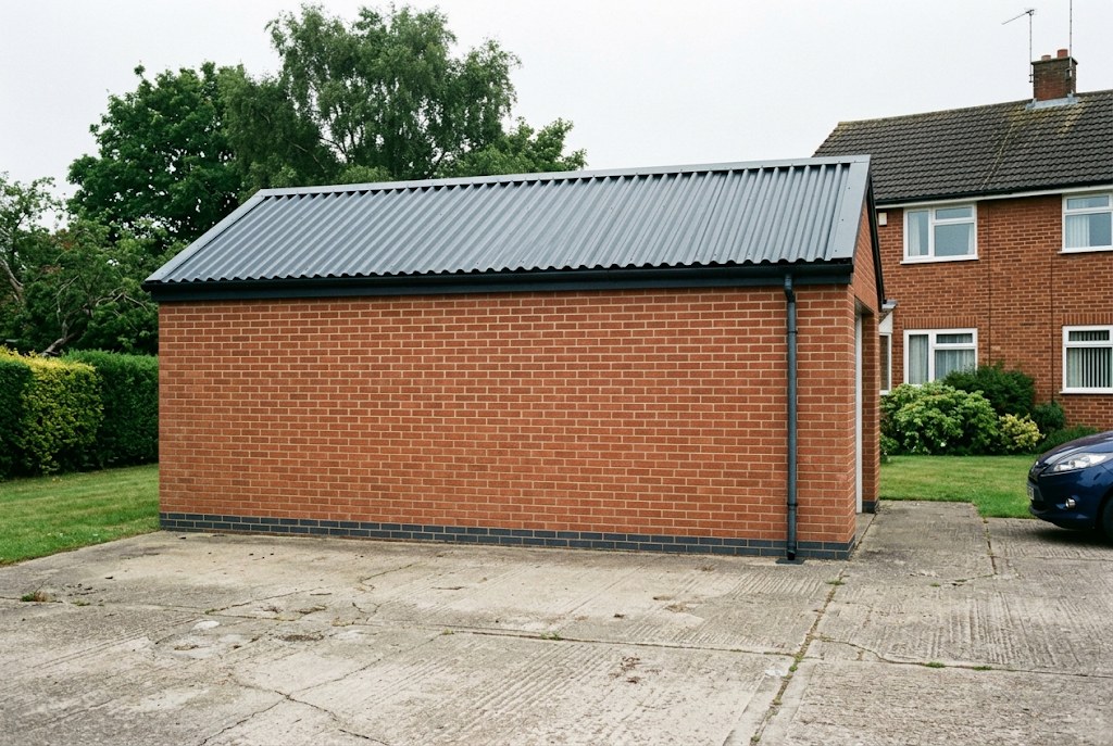 Garage in Coventry with a new dark steel roof after asbestos removal